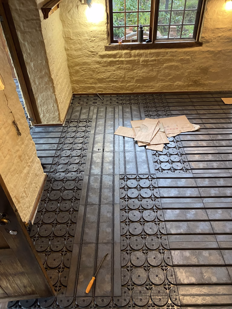 HOYA Ondol panels laid across a room and around the doorway in the Daylesford cottage, ready for the pipe