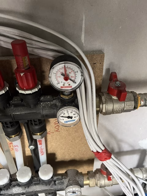 Close-up of the pressure gauge and temperature gauge on the hydronic manifold in the O'Connor ACT renovation